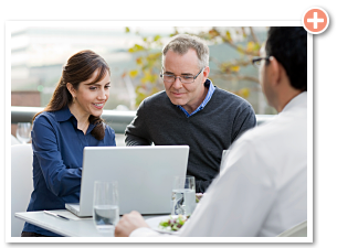 two businesspeople happily reading content on a laptop